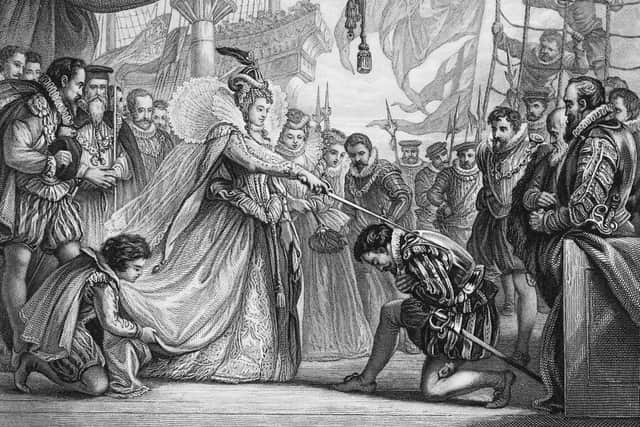 Queen Elizabeth I of England (1533 - 1603) knights explorer Sir Francis Drake (c.1540 - 1596) on board his ship, the Golden Hind at Deptford