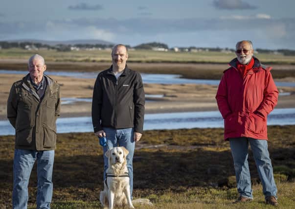 Duncan Mackay (left), Michael Smith, together with Molly the dog, and Angus McCormack on the route, with ‘the Cob’ in the background. (Photo: Sandie Maciver / SandiePhotos)