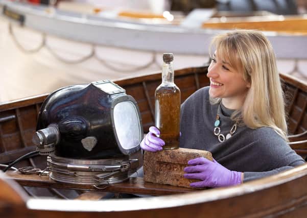 Abigail McIntyre, Senior Curator at the Scottish Maritime Museum, pictured with the eighty year old bottle of Scottish whisky salvaged from the 1923 SS Politician. (Photo: Martin Shields)