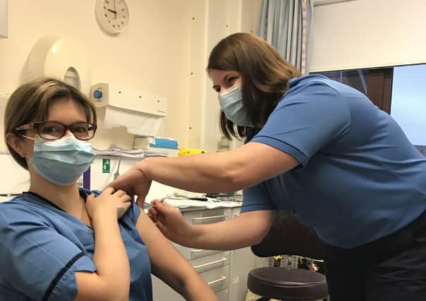Lynsey Mackenzie, Community Staff Nurse receives the very first vaccine on the islands.