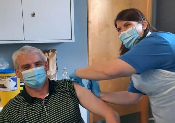 Scottish Ambulance Service Paramedic D.A. MacInnes receives the vaccine administered by NHS Western Isles Occupational Health Nurse, Marion Campbell.