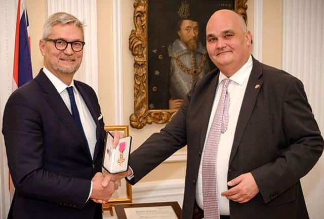 Erik Østergaard (left) receiving his Honorary OBE from British Ambassador Dominic Schroeder in February 2020