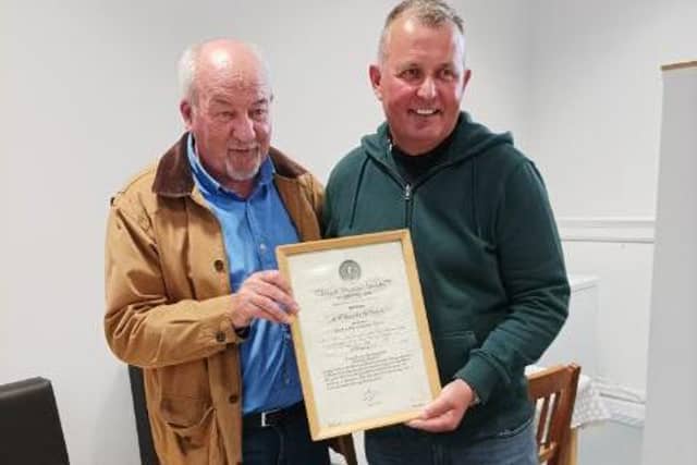 Alasdair and John Angus with the certificate awarded all these years ago.