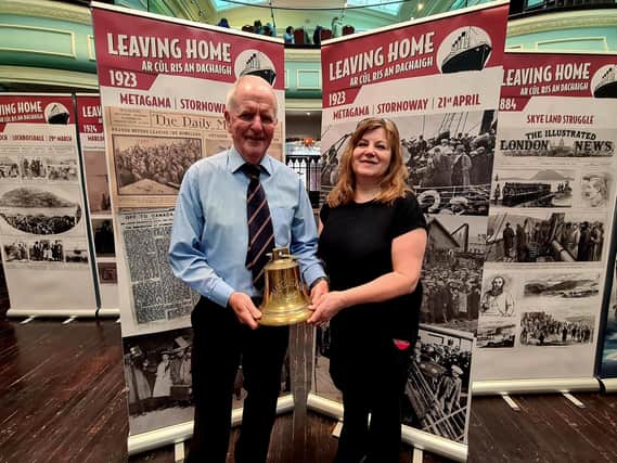 Liza Mulholland presents the bell to Ken Galloway of the Stornoway Historical Society.