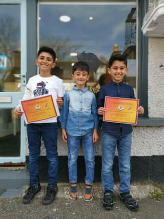 The three brothers Abdullah, Anas and Majd. Abdullah and Majd holding their Gaelic Certificates.