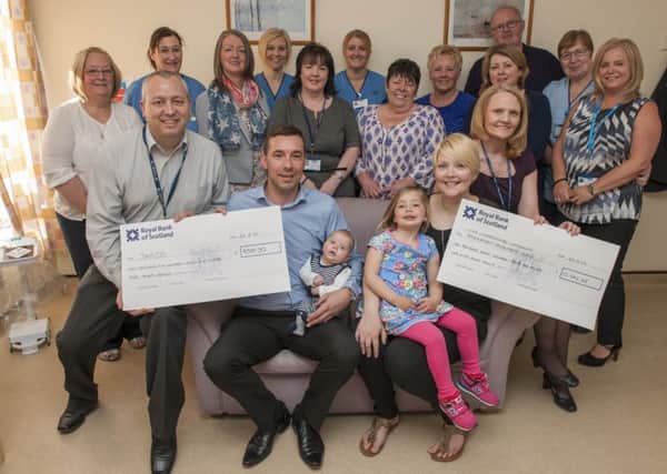 Back at the hospital...Vicky and David with their toddler Emmy and baby Jude present cheques to the hospital and stillbirth charity Sands  (Pic by Sarah Peters)