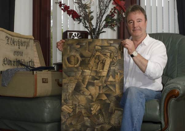 Dominic Currie at home with the Picasso painting he found in a suitcase in his attic. Pic: Kelly Muir