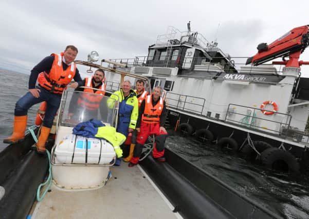 Visiting their new feed barge were (left to right) Ben Hadfield, Stewart Davidson, Robbie Mackenzie, James Morrison (all of Marine Harvest) and Douglas Johnson of AKVA. Photo credited to Malcolm MacLeod, Stornoway.