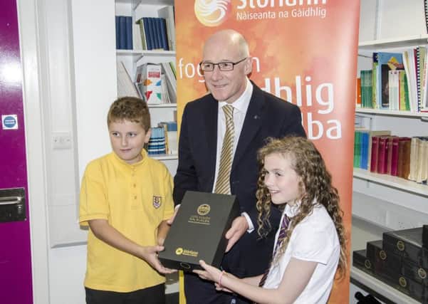 Deputy First Minister John Swinney officially launches the new game with the help of  pupils from Laxdale School.