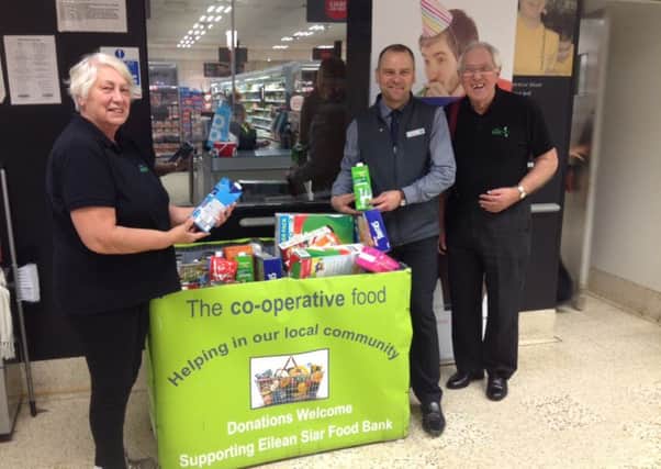 Pictured is store manager Steven Cooper, with a representative of the Eilean Siar food bank, as they hand over the produce donated by Co-op customers.