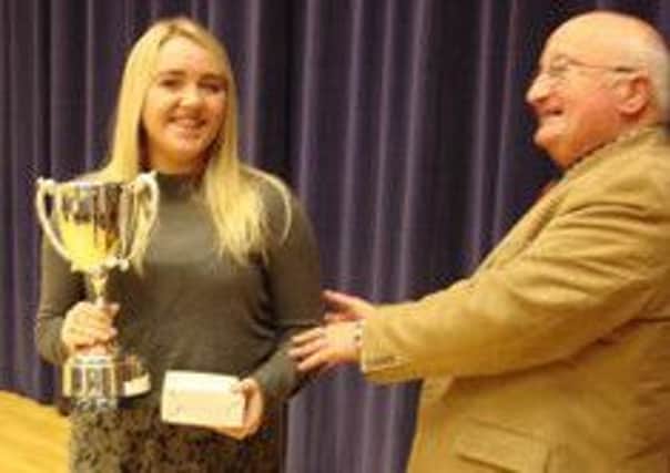 Amy McClements being presented with the Donald Stewart Memorial Trust trophy by Sandy Matheson.