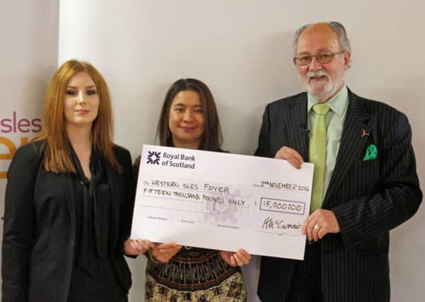 Angus McCormack, chairman of Point and Sandwick Trust, presenting the cheque to Foyer Project Leader Rebecca Mahony, (centre), and support worker Anna Campbell.