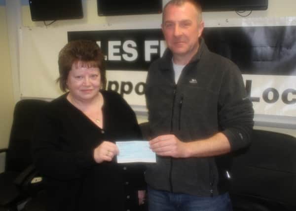 Kathleen Maciver of Isles FM with Simon Pearson who donated Â£2,000 to the station.