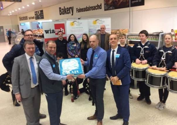 Simon Wetherell, Co-op Director of Facilities Management, Macaulay Road Store Manager, Steven Cooper, Cromwell Street Store Manager Steven Macphail, and Divisional Managing Director John McNeill celebrate handing over Â£38,429 to three local causes.