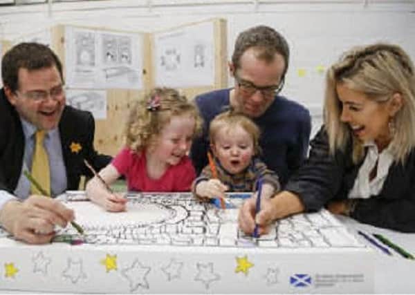 Mark McDonald, Mona and Magnus with dad Patrick and Leanne Young pictured helping design a baby box.