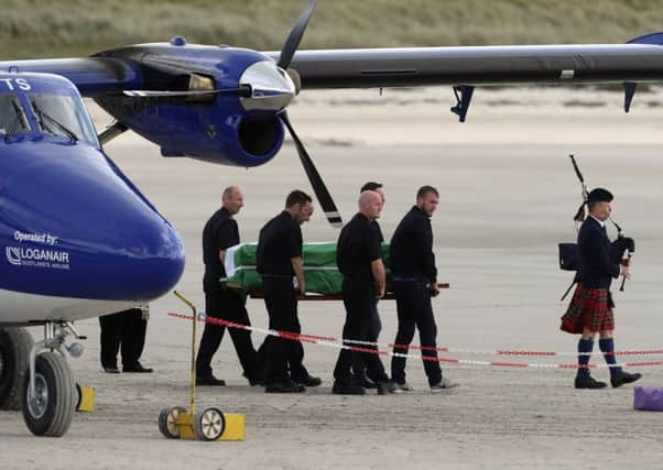 The coffin of Eilidh MacLeod draped in the Barra flag is carried across Traigh Mhor beach at Barra airport after it arrived by chartered plane yesterday. Photo by Andrew Milligan/PA Wire
