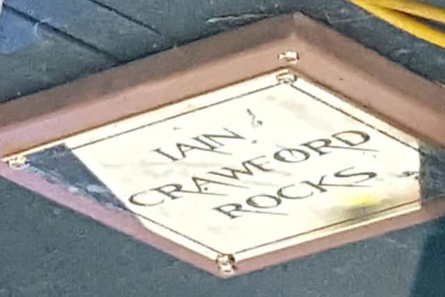 Plaque on stage in memory of Iain Crawford 'Crawfie'.