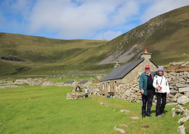 Angela MacLeod with her father next to the museum on St Kilda during their recent visit