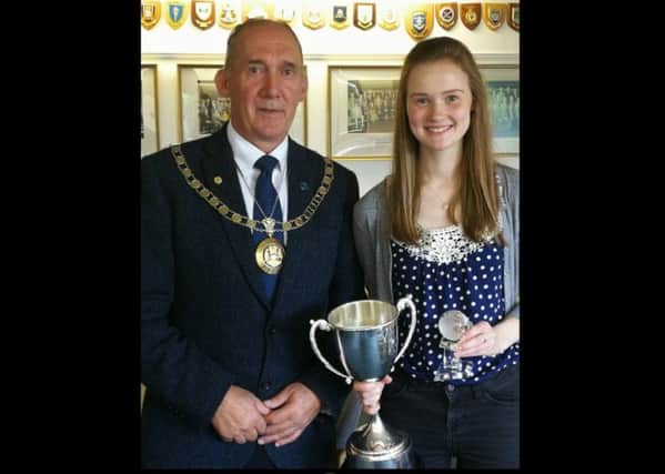 Catriona Bain being presented with the Donald Stewart Memorial Trust trophy by Comhairle Convener, Cllr. Norman A Macdonald.