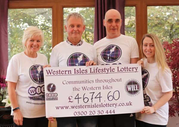 Volunteers from the Western Isles Community Society with a cheque for community groups