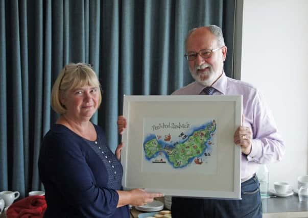 Trust chairman Angus McCormack presented Jenny with a picture as a retirement gift during the boards away day at Talla na Mara in Horgabost recently.