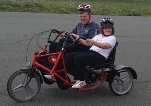Ann Macleod and Uisdean Russell Smith, of SpÃ²rsnis, enjoying a cycle on the borrowed Voluntary Action Lewis bike   similar to the one currently on its way to Ness.