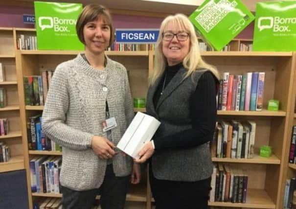Library assistant Helene LaGrange (left) presents Fiona Knape with her prize a new ipad mini donated by Bolinda UK.