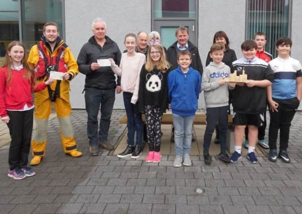 Pupils are pictured presenting the cheques to Stornoway Trust and RNLI representatives.