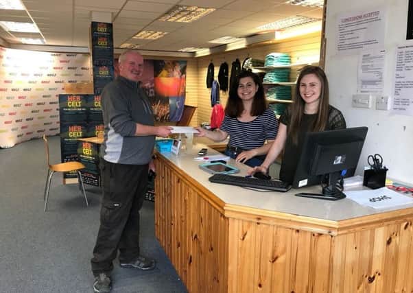 Customer Iain Maclean picking up his tickets from the new HebCelt shop.