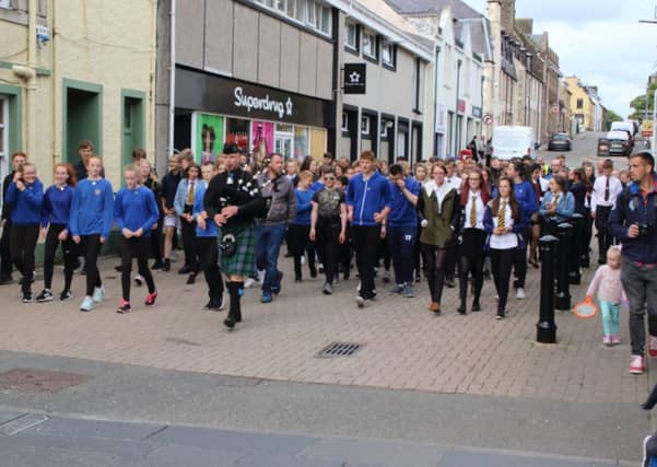 A piper leads S3 and S4 pupils from all four Comhairle secondary schools from the Nicolson Institute into Stornnoway town centre as part of the opening ceremony for the