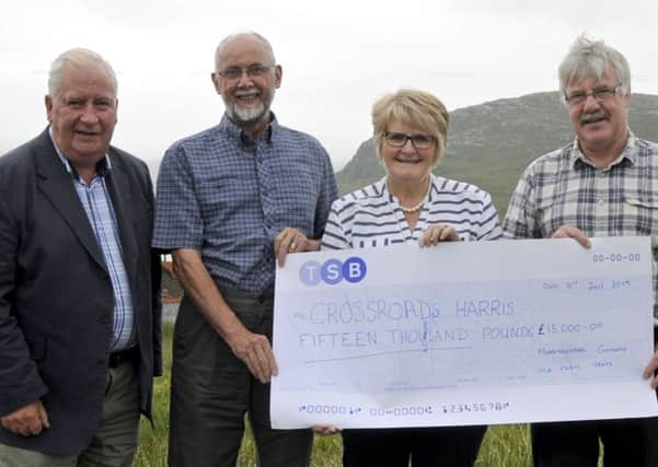 Pictured are Donnie Morrison, MCWFT, Ronnie Morrison, Treasurer Crossroads Care Harris, Dolly Maclean Chairperson CCH and Iain Maciver MCWFT with presentation cheque.